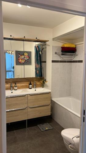 une salle de bain avec un lavabo, une baignoire et des toilettes dans l'établissement Appartement avec Jardin - La Plaine Saint Denis, à Saint-Denis