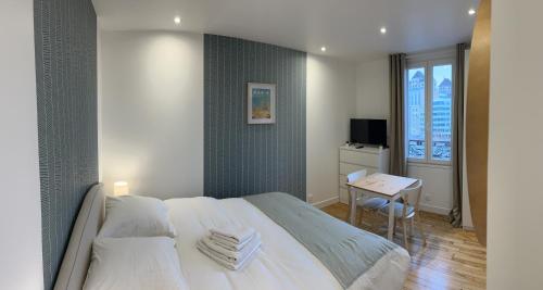 a bedroom with a bed and a table with a chair at Studio number 10 in Pantin