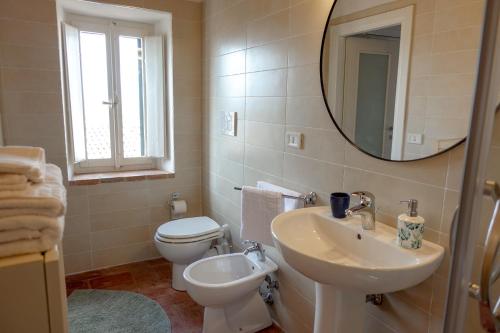 a bathroom with a sink and a toilet and a mirror at CASA NINETTA GUEST HOUSE in Urbisaglia