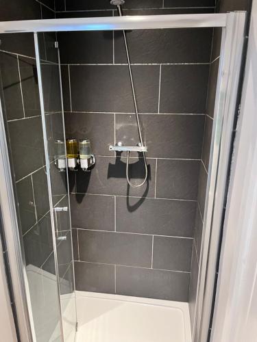 a bathroom with a shower with a glass door at The Railway Apartments in Haydon Bridge