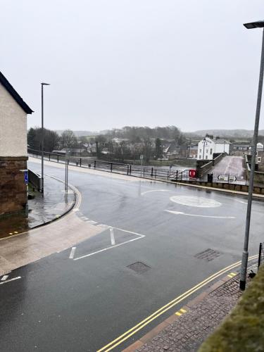 an empty street in a town with a fence at The Railway Apartments in Haydon Bridge