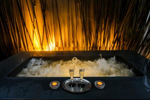 a bath tub with two champagne glasses in it at Hotel Bleichibeiz in Wald