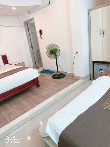 a room with two beds and a fan in it at Khách Sạn An Chi in Ho Chi Minh City