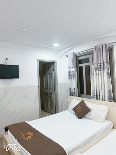a bedroom with a bed and a flat screen tv at Khách Sạn An Chi in Ho Chi Minh City