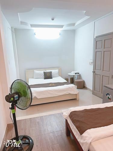 a bedroom with a bed and a fan on the floor at Khách Sạn An Chi in Ho Chi Minh City