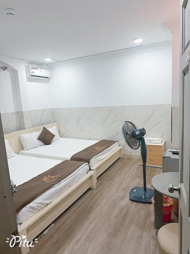 a bedroom with a bed and a fan at Khách Sạn An Chi in Ho Chi Minh City