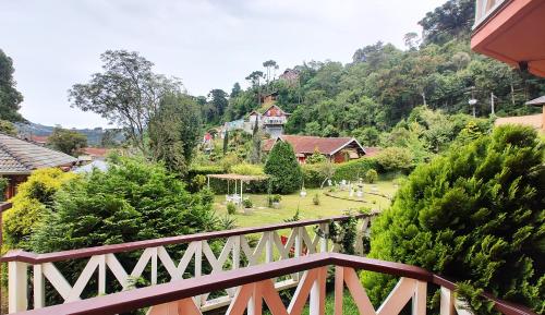 a wooden bridge with a view of a garden at Pousada Casa dos Sonhos in Campos do Jordão