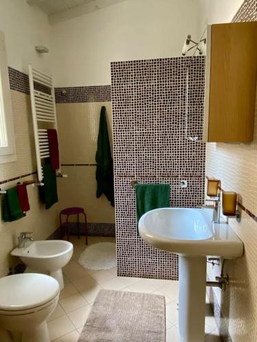 uma casa de banho com 2 lavatórios, um WC e um chuveiro em La casetta in fondo all'orto em Viareggio