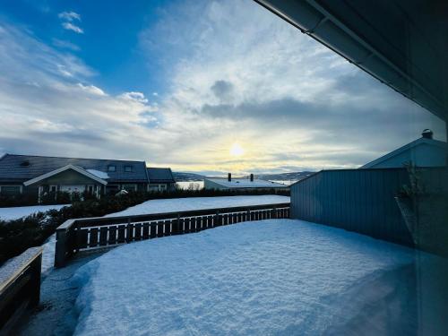 a snow covered yard with the sun setting in the distance at Nydelig perle ved Tyrifjorden 