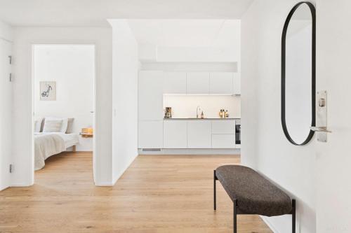 ein weißes Apartment mit einem Schlafzimmer und einem Stuhl in der Unterkunft Spacious waterfront apartment with marina and sea view in Arhus
