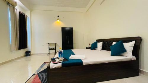 1 dormitorio con 1 cama con almohadas azules y blancas en ATULYAM STAYS SUSHANT GOLF CITY LUCKNOW en Lucknow
