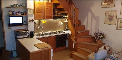 eine Küche mit einem Waschbecken und eine Küche mit einer Treppe in der Unterkunft Appartamento Pepe in Castello di Fiemme