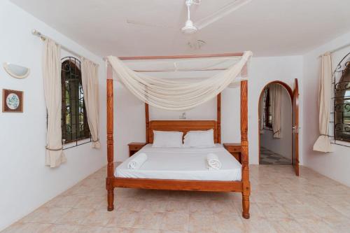 a bedroom with a bed with a canopy at Sal & Lala Castle watamu in Watamu