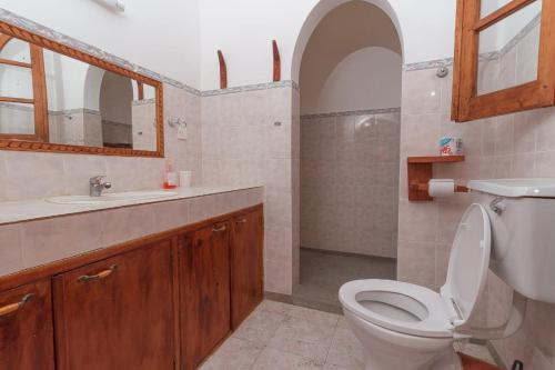 a bathroom with a toilet and a sink and a mirror at Sal & Lala Castle watamu in Watamu