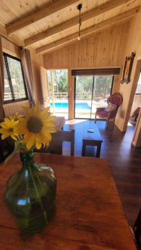 a vase with a flower on a table in a room at Cabañas Doña Regina in Constitución