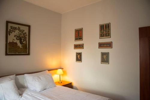 Kompleksowo wyposażony apartament w centrum في كراكوف: غرفة نوم بسرير وصور على الحائط