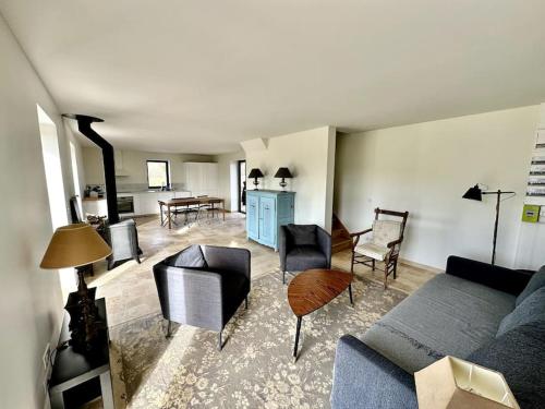 un salon avec un canapé et des chaises dans l'établissement une maison d'hôtes alliant charme et confort, à Saint-Pierre-du-Val