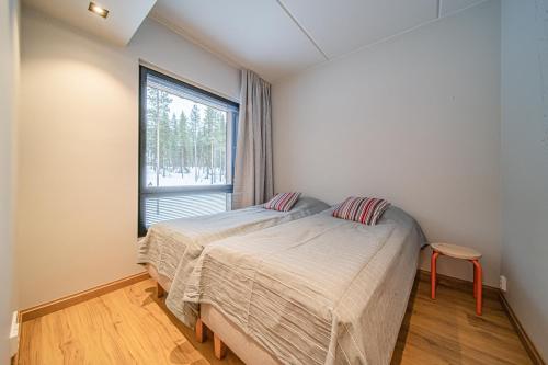 a bedroom with two beds and a window at Levillas Levin Cranberry C24 in Levi