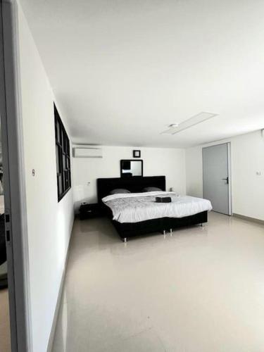 une chambre avec un lit dans une pièce blanche dans l'établissement Fabuleuse villa Marseille -7 chambres -14 pers avec grande piscine 2 jacuzzis, à Marseille