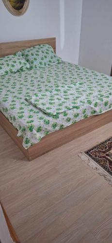 ein Bett mit einer grünen und weißen Decke drauf in der Unterkunft Zori de zi 