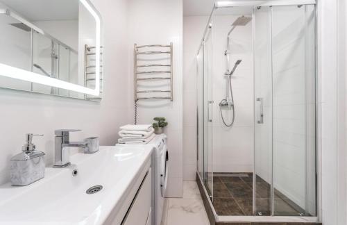 a white bathroom with a shower and a sink at Люкс на Бориспільській ЖК Олімпік Парк, генератор на будинку in Kyiv