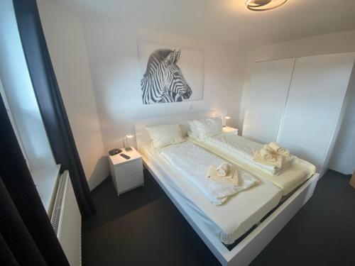 a bedroom with a bed with a zebra picture on the wall at Residenz Mühlenberg Typ A in Willingen