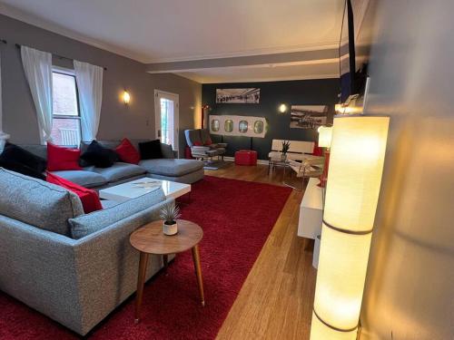 a living room with couches and a red rug at Coolest condo ever- Indy's best at your door step - Central Mass Ave! in Indianapolis