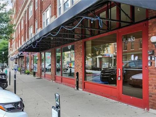 a store front with red doors on a city street at Coolest condo ever- Indy's best at your door step - Central Mass Ave! in Indianapolis
