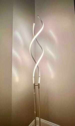 a metal lamp in the corner of a room at Coolest condo ever- Indy's best at your door step - Central Mass Ave! in Indianapolis