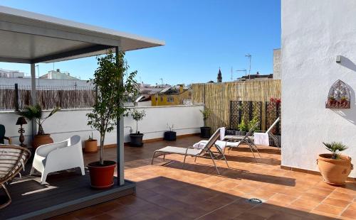 a patio with chairs and tables on a roof at La Terraza de Porvenir 10 - Jerez de la Frontera in Jerez de la Frontera