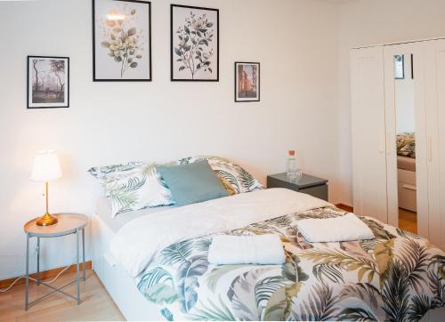 een witte slaapkamer met een bed met kussens erop bij Moderne 3-Zimmer-Wohnung in Top-Lage in Karlsruhe