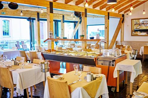 a restaurant with tables and chairs and a bar at Penzion Lípa in Krásná Lípa