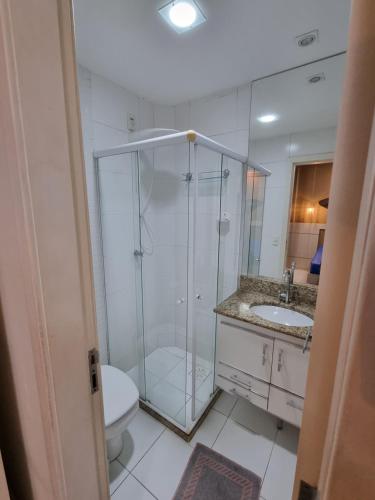 a bathroom with a shower and a toilet and a sink at Apartamento FRENTE PARA 0 MAR - PÉ NA AREIA - 3 SUITES COM AR CONDICIONADO, 2- VAGAS DE GARAGEM - FINAMENTE DECORADO - PRAIA DO MORRO-INTERNET -WI-FI -TV COM SERVIÇOS DE DISNEY PLUS - NETFLIX -HBO MAX -STAR MAX - JOGOS AMAZON FIRE STICK - ALEXIA in Guarapari