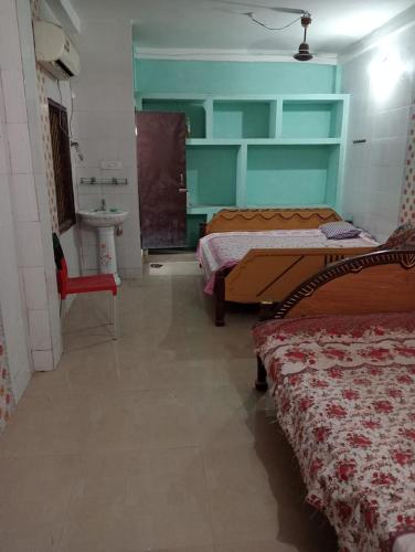 um quarto com duas camas e um lavatório em WeKare Puri Temple Front, Near Jagannath Temple em Puri