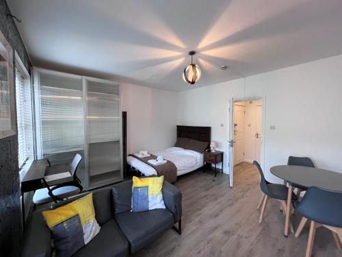 a living room with a bed and a couch and a table at Flat in central London with large patio in London