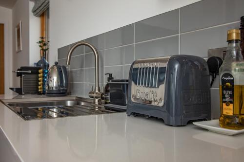 einen Toaster auf einer Küchentheke neben einer Spüle in der Unterkunft Rowan Cottage in Kensaleyre