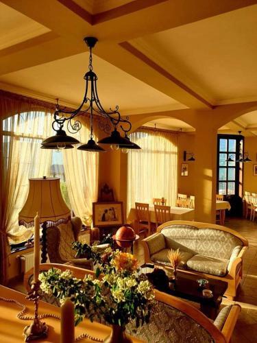 a living room with a couch and a table at Pensiunea Casa Mircea & Restaurant in Eşelniţa