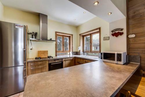 Il comprend une grande cuisine équipée d'un réfrigérateur en acier inoxydable. dans l'établissement Chalet Premiere Neige, à Le Fornet