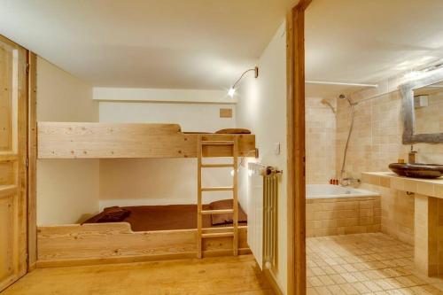een kamer met een stapelbed en een badkamer bij Magnifique et Chaleureux Chalet à Val d'Isere in Le Fornet