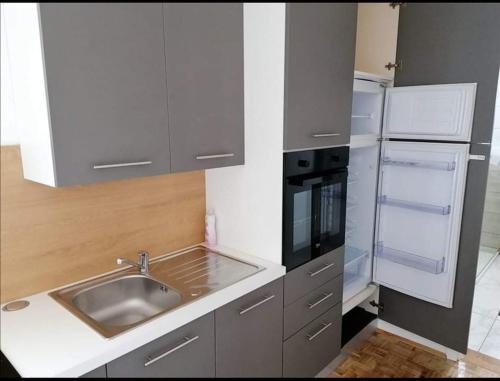 a small kitchen with a sink and a refrigerator at Apartmani Milat in Sveti Filip i Jakov