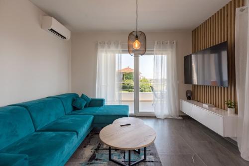un salon avec un canapé bleu et une table dans l'établissement Apartment Karlo, à Trogir