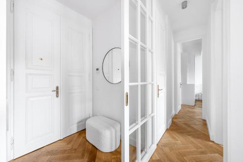 a white hallway with a white chair and a door at Luxury apartment in the center in Prague
