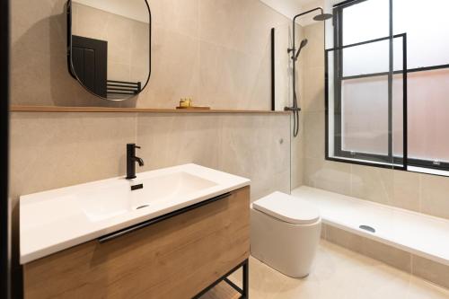 Un baño con lavabo, inodoro y espejo. en Lord Street Lofts, en Southport