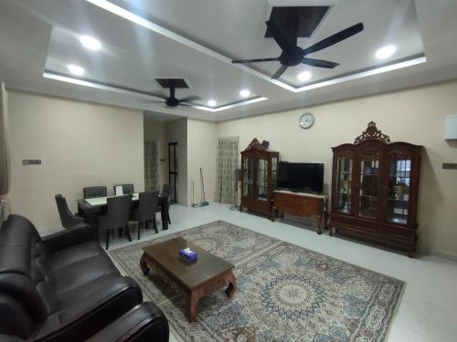 een woonkamer met een bank en een tafel bij Zahani Homestay in Kuala Terengganu