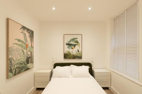 um quarto branco com uma cama e uma janela em Lord Street Lofts em Southport
