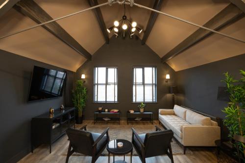 a living room with a couch and chairs at Lord Street Lofts in Southport