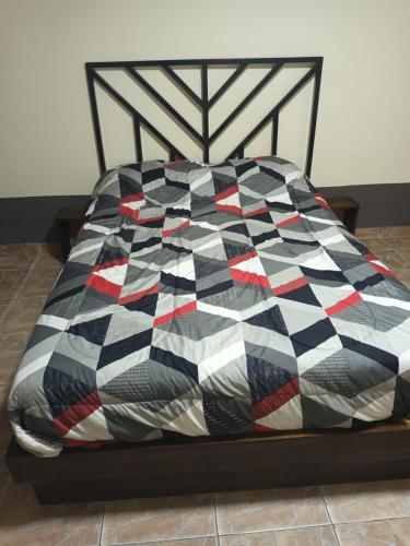 a bed with a black and white quilt on it at la pipi in Las Heras