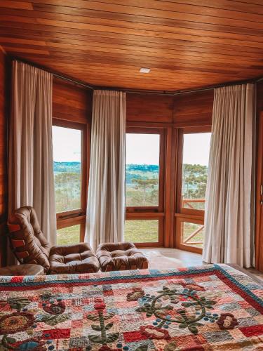 a bedroom with a large bed and large windows at Tenuta Bergamaschi in São Joaquim