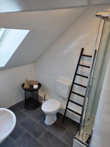 uma casa de banho no sótão com um WC e uma escada em Wohlfühlende Wohnung nähe Dortmund em Witten