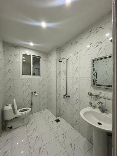 uma casa de banho branca com um WC e um lavatório em Kharian-Inn Hotel em Khāriān